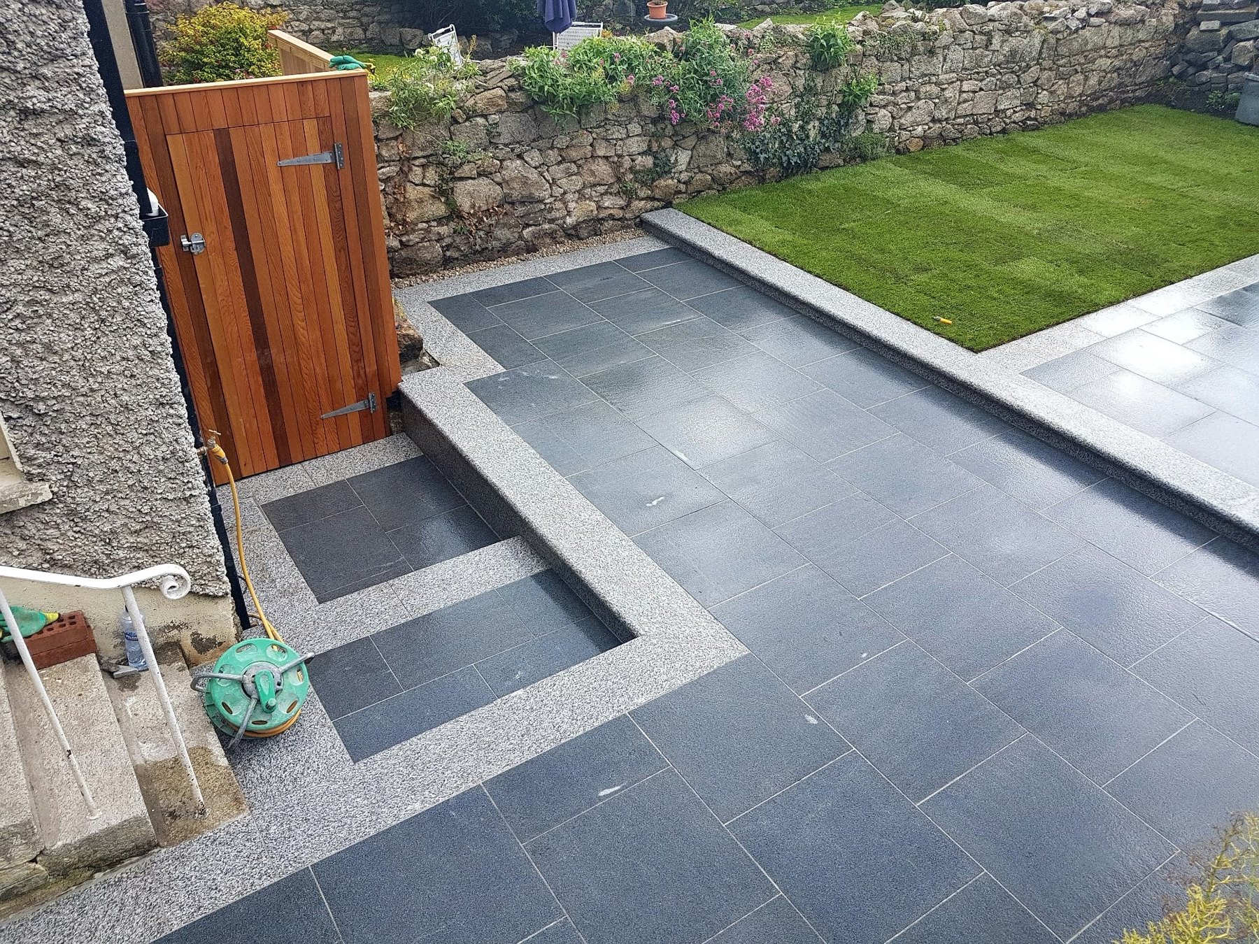 Raised patio and stone steps with timber gate